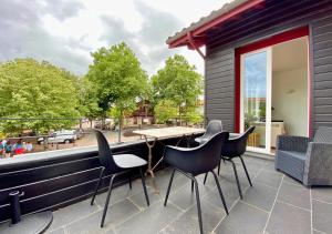 a patio with chairs and a table on a balcony at G-63 - Appartement de standing en plein coeur d'Hossegor in Soorts-Hossegor