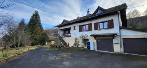 a white house with a garage and a driveway at Gîte des sources in Salbert