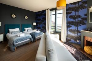 a bedroom with two beds and a couch at Maison Valmer - L'armateur, élégant penthouse classé 4 étoiles in Le Havre