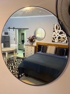 a mirror reflecting a bedroom with a bed and a kitchen at Little West in Margate