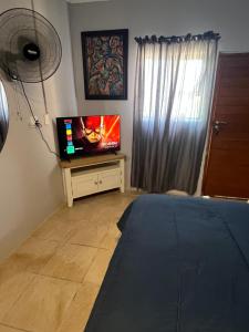 a living room with a tv and a bed at Little West in Margate