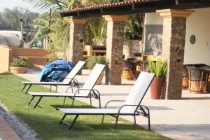 a row of white chairs sitting on the grass at Luahara Glamping Domo Experience La Primavera - Presa de las Tortugas in Orendain
