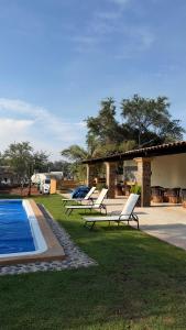 a group of lounge chairs sitting next to a pool at Luahara Glamping Domo Experience La Primavera - Presa de las Tortugas in Orendain