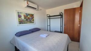 a bedroom with a bed with a white sheets and a picture on the wall at Brisas do Lago II in Paulo Afonso