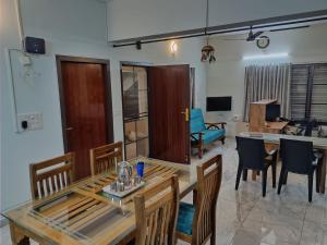 a dining room and living room with a table and chairs at Dwaraka Serviced Villa - Near Sree Padmanabha Swamy Temple, Trivandrum -AC Rooms & Parking in Trivandrum
