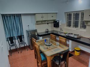 a kitchen with a table and chairs in a kitchen at Dwaraka Serviced Villa - Near Sree Padmanabha Swamy Temple, Trivandrum -AC Rooms & Parking in Trivandrum