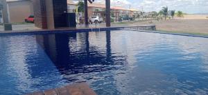 a swimming pool with blue water in front of a house at Brisas do Lago II in Paulo Afonso +26 photos