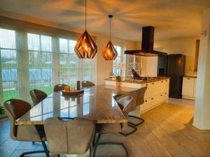 a large kitchen with a dining table and chairs at Villa Pura Vida in Oud-Ade