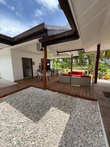 an outdoor deck with a large umbrella and a table at MOOREA CHILL and BEACH LODGE in Teavaro