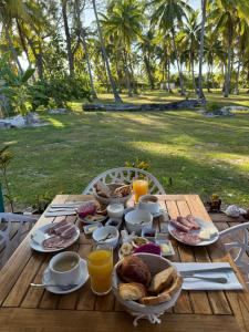a wooden table with food and orange juice on it at MOOREA CHILL and BEACH LODGE in Teavaro