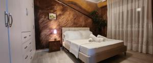 a bedroom with a white bed and a wooden wall at Eye Luxury Penthouse & apartment in Sarandë