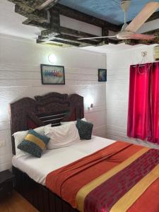 a bedroom with a large bed with red curtains at Kera Houseboats Alleppey in Alleppey