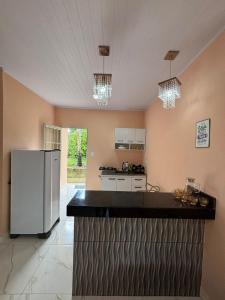 a kitchen with a white refrigerator in a room at pousada Bela Rosa in Santa Cruz Cabrália