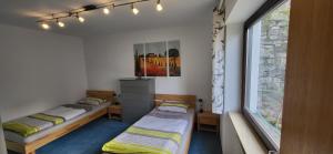 two beds in a room with a window at Ferienwohnung Vogelsang in Sachsenheim