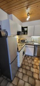 a kitchen with white appliances and a wooden ceiling at Ferienwohnung Vogelsang in Sachsenheim