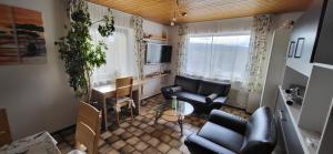 a living room with black leather furniture and a table at Ferienwohnung Vogelsang in Sachsenheim