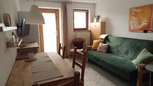 a living room with a green couch and a table at Ferienwohnungen Fuchssteige in Heidenheim an der Brenz