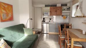 a living room with a green couch and a kitchen at Ferienwohnungen Fuchssteige in Heidenheim an der Brenz
