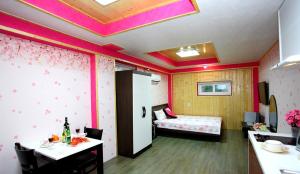 a room with a bedroom with a bed and a table at Pinky Marine Pension in Namhae +28 photos