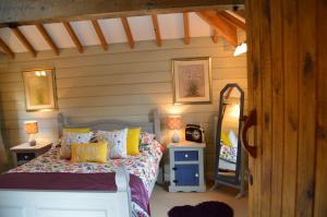 a bedroom with a bed with pillows and a mirror at Stable Cottage at Hanley Mill in Tenbury +18 photos