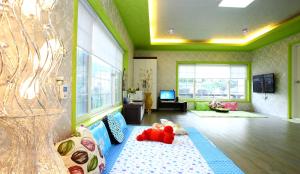 a living room with a couch and a tv at Pinky Marine Pension in Namhae