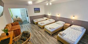 a room with three beds and a living room at Pod Kasztanem in Świnoujście