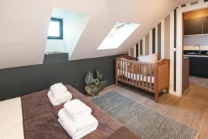 a bedroom with a crib with white towels at Maison Valmer - Le négociant, élégant F2 classé 4 étoiles in Le Havre