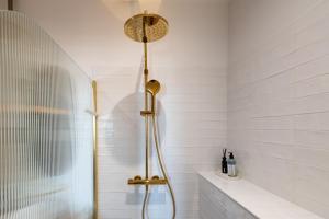 a shower in a bathroom with white tiles at Maison Valmer - Le négociant, élégant F2 classé 4 étoiles in Le Havre +29 photos