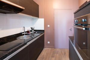 a small kitchen with a sink and a refrigerator at Maison Valmer - Le négociant, élégant F2 classé 4 étoiles in Le Havre