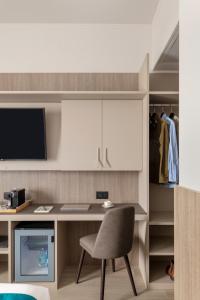 a desk with a chair and a computer in a room at Living Hotel Milano in Cornaredo