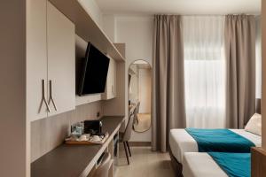 a hotel room with a bed and a television at Living Hotel Milano in Cornaredo
