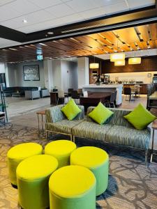 a lobby with couches and yellow chairs and a table at Wingate by Wyndham Kamloops in Kamloops