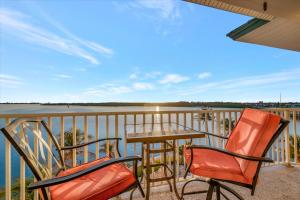 a balcony with a table and chairs and a view of the water at Sunsets Waterview Balcony King Bed & Heated Pool in St. Petersburg