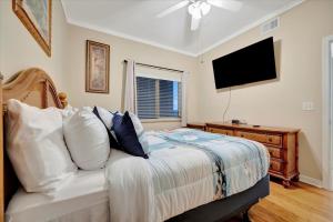 a bedroom with a bed with a television on the wall at Sunsets Waterview Balcony King Bed & Heated Pool in St. Petersburg