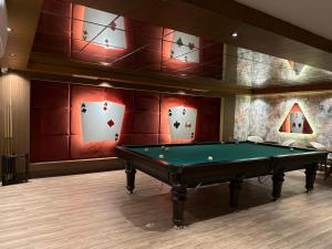 a pool table in a room with playing cards on the wall at Family Apartment with pool Eden Valley in Alanya