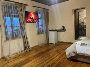a room with a bed and a television on the wall at Harmony Guest House in Ijevan