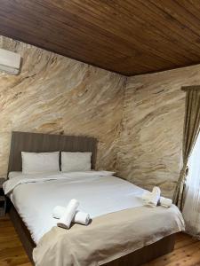 a bedroom with a bed with two slippers on it at Harmony Guest House in Ijevan