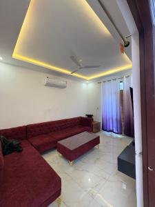 a living room with a red couch and a tv at Casa Aura Villa in Udaipur