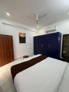 a bedroom with a large white bed and blue cabinets at Casa Aura Villa in Udaipur