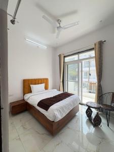a bedroom with a bed and a large window at Casa Aura Villa in Udaipur