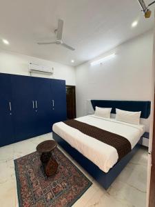 a bedroom with a large bed with blue cabinets and a rug at Casa Aura Villa in Udaipur