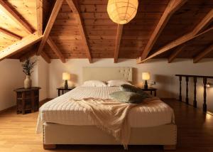 a bedroom with a large bed with wooden ceilings at Joya Luxury Villas in Kypseli