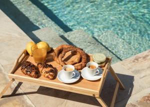 a tray of food on a table next to a pool at Joya Luxury Villas in Kypseli