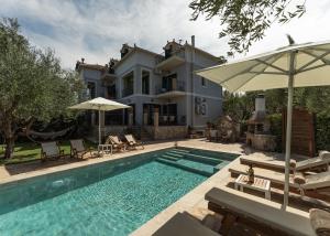 a villa with a swimming pool and a house at Joya Luxury Villas in Kypseli