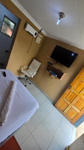 a room with a bed and a tv and a chair at 6 Tiger guest house in Katlehong