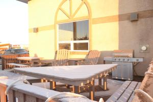 a patio with a table and chairs and a grill at Aurora Park Inn & Suites in Dawson Creek