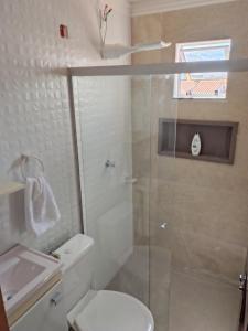 a bathroom with a shower and a toilet and a sink at Aconchego da Alegria!!! in Porto Seguro