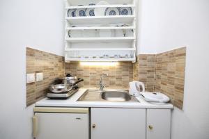 eine kleine Küche mit weißen Schränken und einer Spüle in der Unterkunft Augusta Studios & Apartments in Naoussa + 79 Fotos