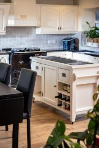 a kitchen with white cabinets and a counter top at Manse On The Beach in Kirkistown