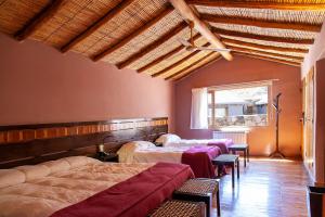 a bedroom with two beds and a window at La Comarca Hotel in Purmamarca